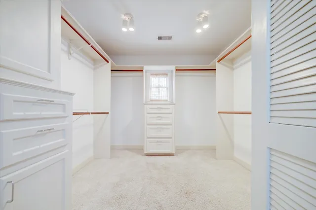 a view of walk in closet with empty racks