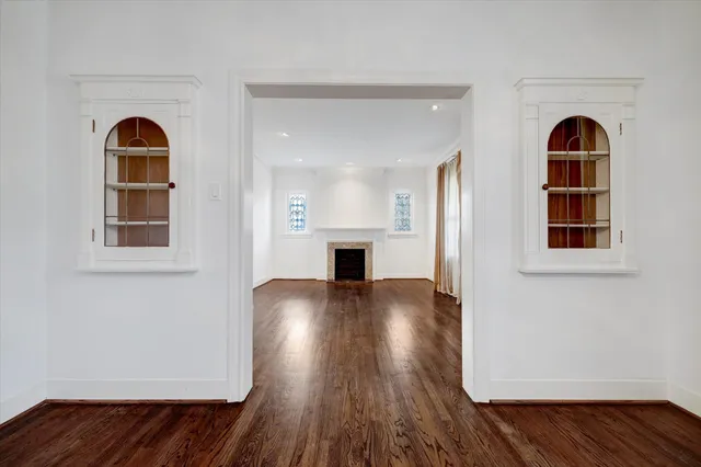 a view of empty room with wooden floor and fireplace