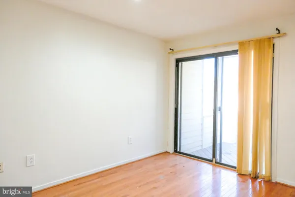 an empty room with wooden floor and doors