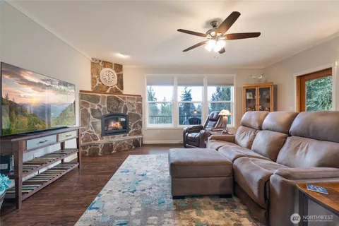 a living room with furniture a flat screen tv and a floor to ceiling window