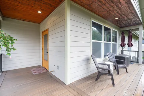 a view of a patio with table and chairs with wooden floor and plants