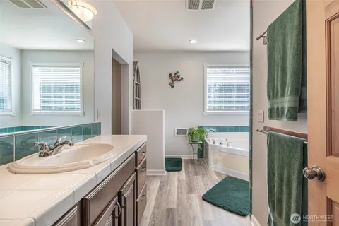 a spacious bathroom with a granite countertop sink and a mirror