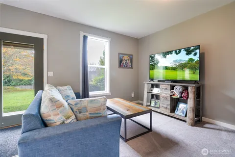 a living room with furniture a flat screen tv and a large window