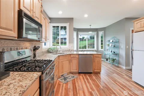 a kitchen with sink a stove and wooden cabinets
