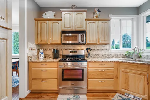 a kitchen with granite countertop a stove microwave and cabinets