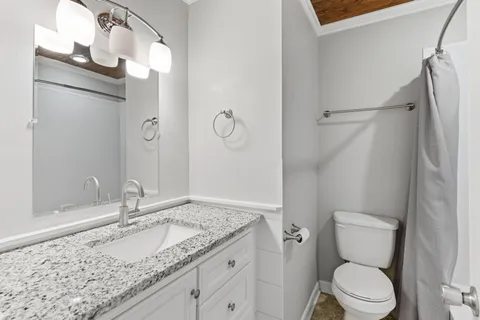 a bathroom with a granite countertop sink toilet and shower