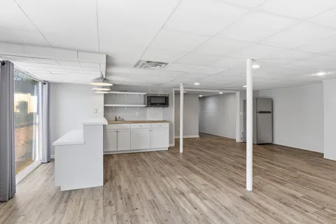 a kitchen with wooden floors and white cabinets