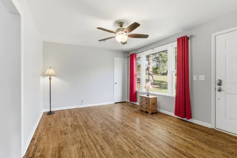 a very nice looking room with a large window and ceiling fan