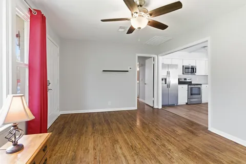 a view of empty room with wooden floor