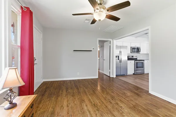 a view of empty room with wooden floor
