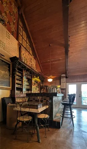 a roof deck with a table and chairs with wooden floor