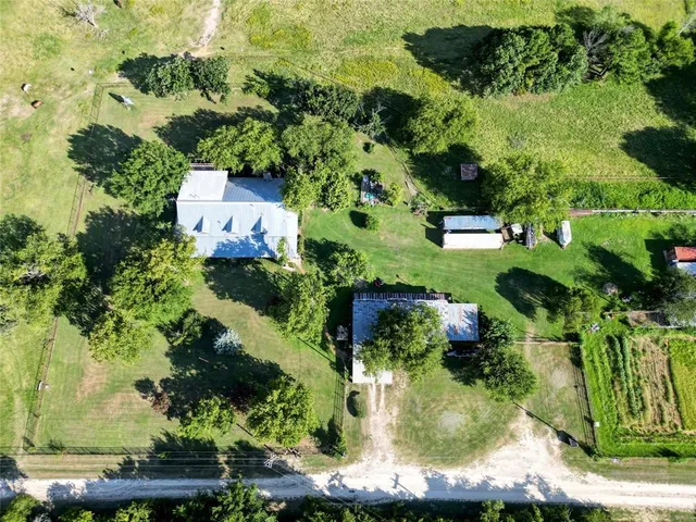 an aerial view of a house with a yard lake lake and mountain view in back
