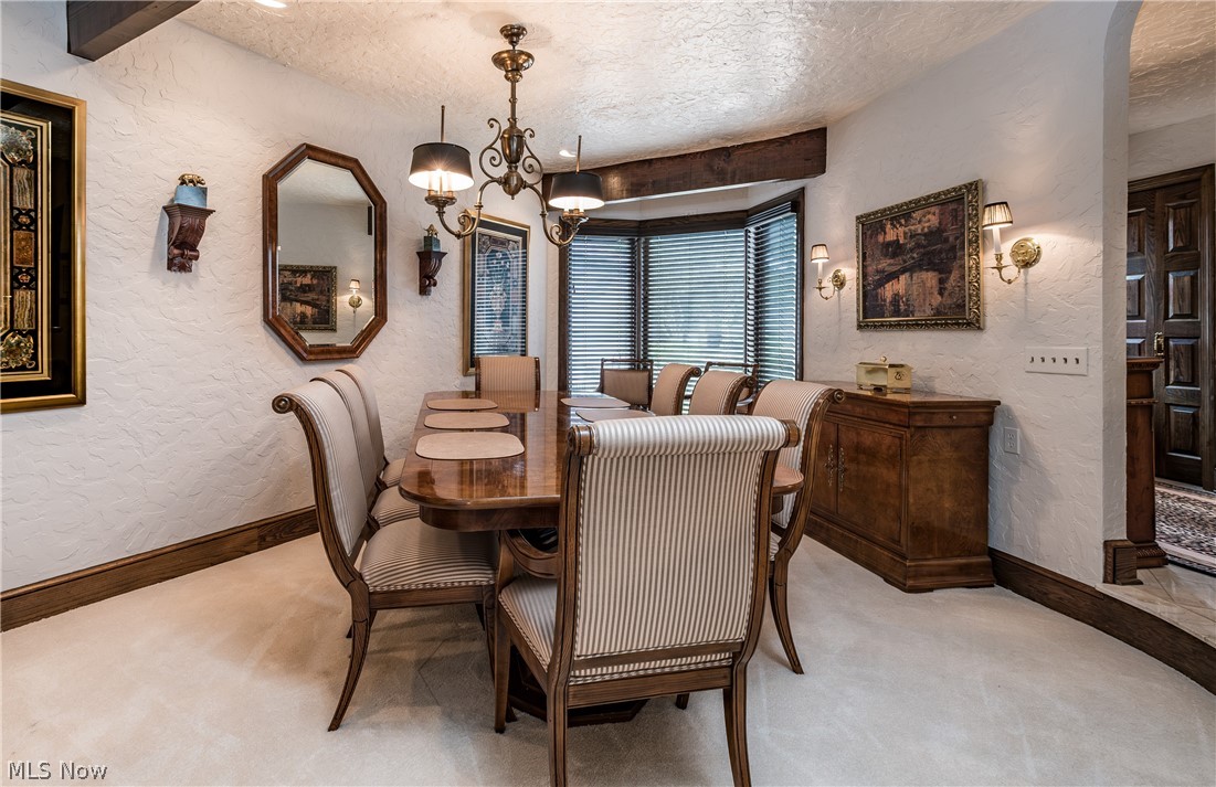 1415 Harbor Drive Northwest Canton, OH 44708 - Photo 7 of 46 Carpeted formal dining space featuring a textured beamed ceiling, bay window and an inviting chandelier