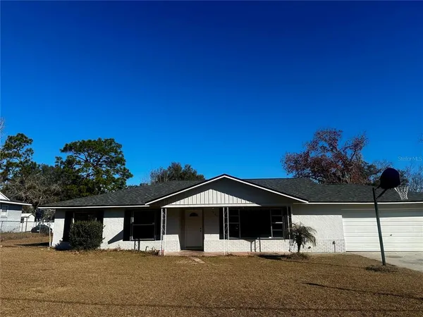 a front view of a house with large trees