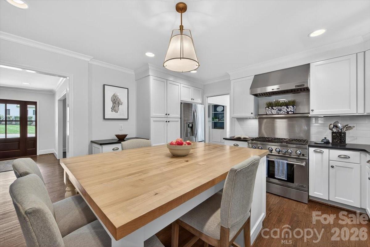 308 Robmont Road Charlotte, NC 28270 - Photo 11 of 43 a kitchen with stainless steel appliances granite countertop a stove a refrigerator a kitchen island a sink dishwasher a dining table and chairs with wooden floor