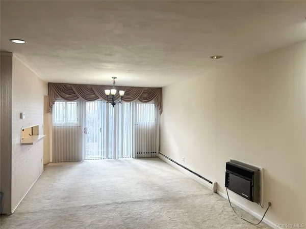 an empty room with windows and cabinet