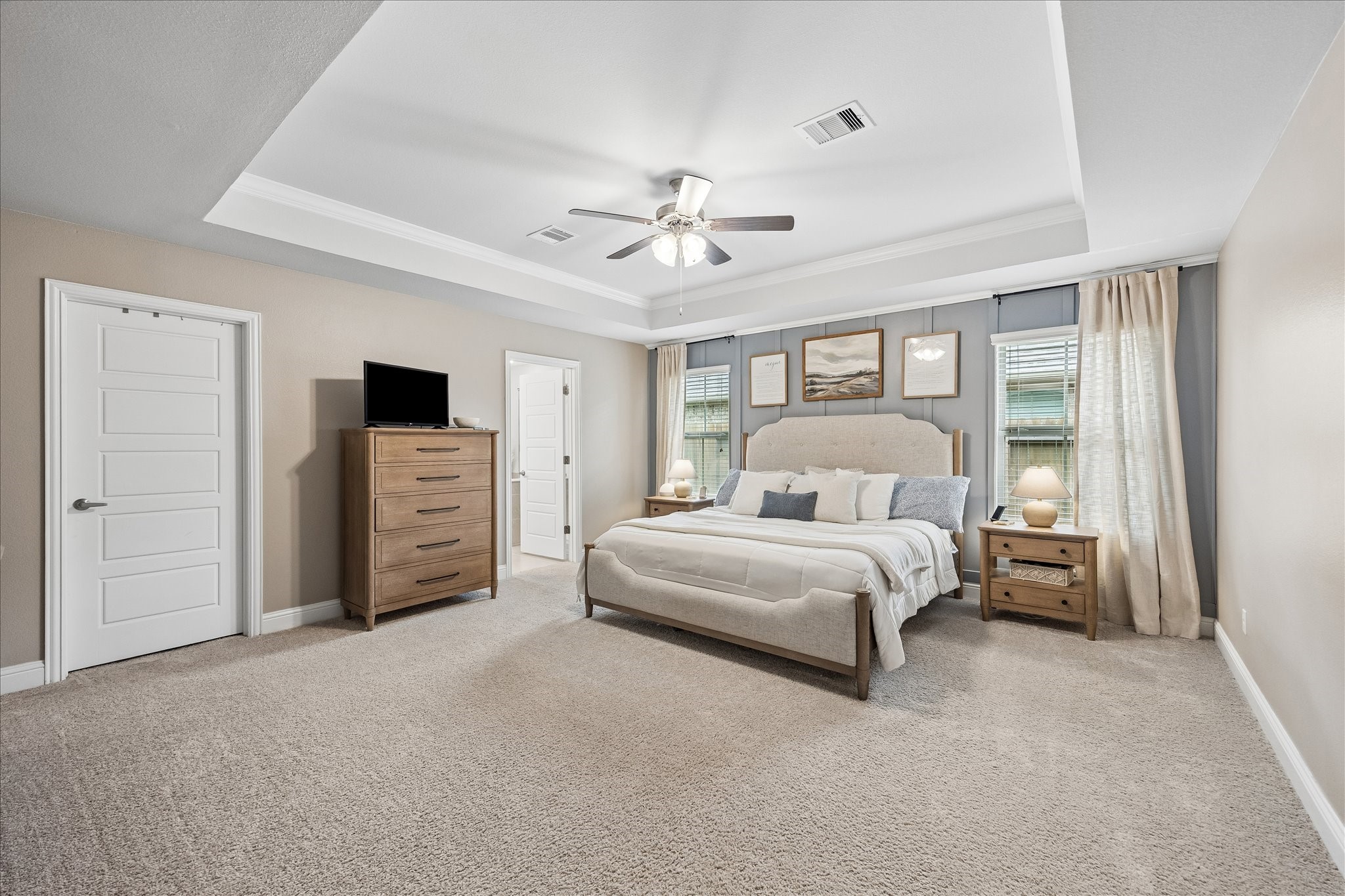 10227 Whitney Reach Drive Rosharon, TX 77583 - Photo 19 of 28 A spacious primary bedroom featuring abundant natural light and an elegant tray ceiling.