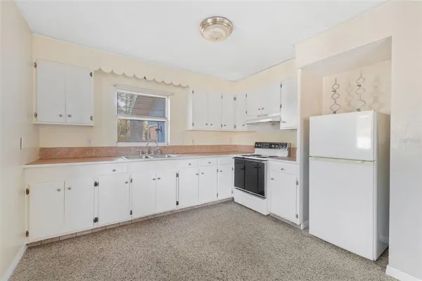 a kitchen with cabinets stainless steel appliances and a window
