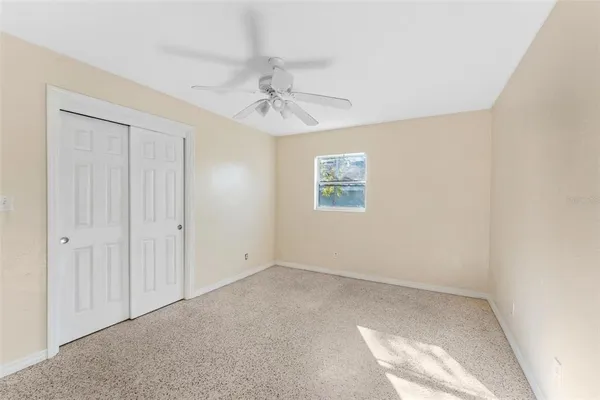 an empty room with windows and fan