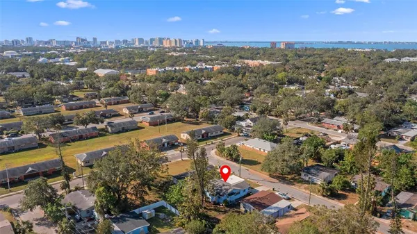 an aerial view of residential houses with outdoor space and trees
