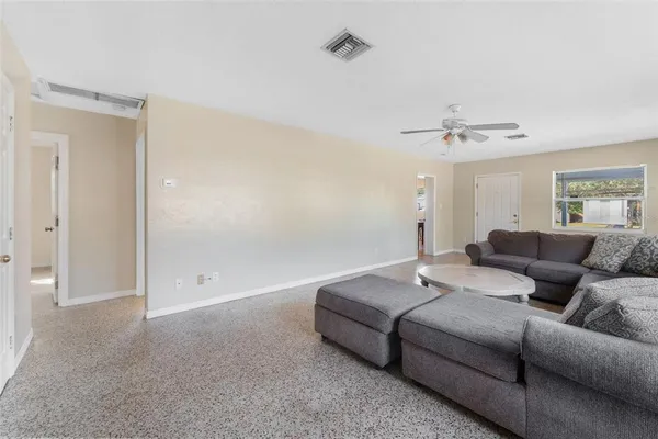 a living room with furniture and a ceiling fan