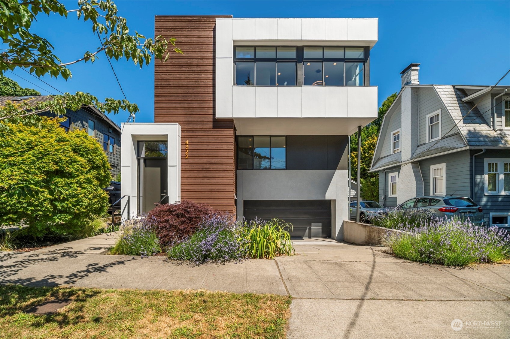 a view of a white house with a yard and potted plants