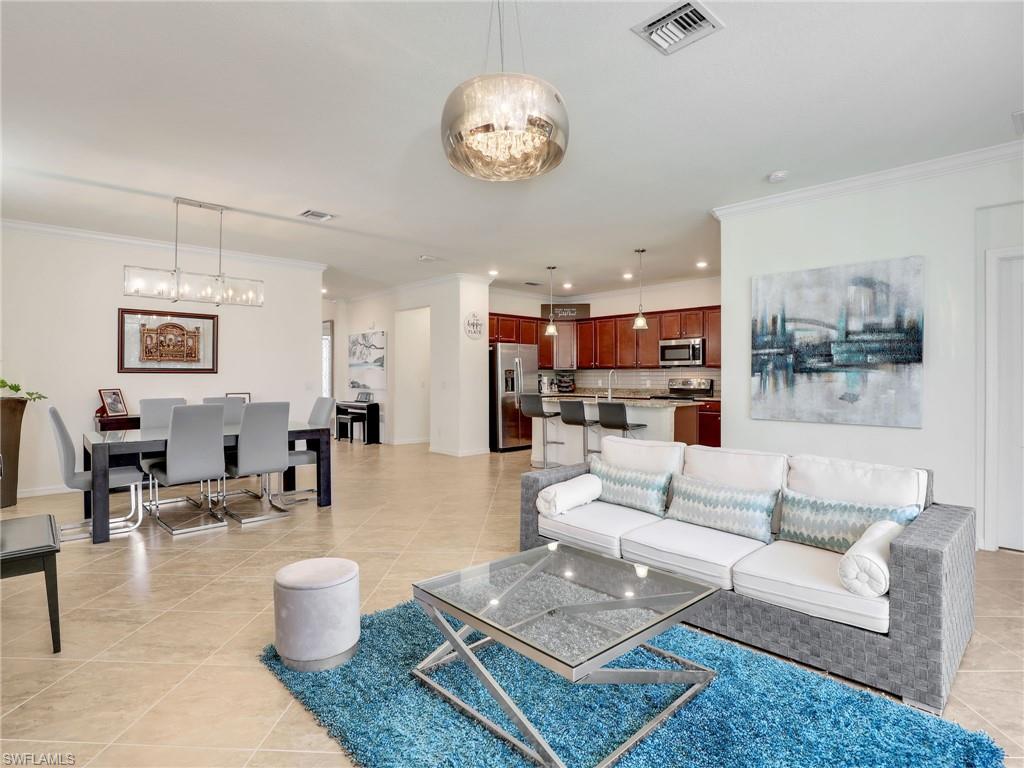 a living room with furniture kitchen view and a chandelier
