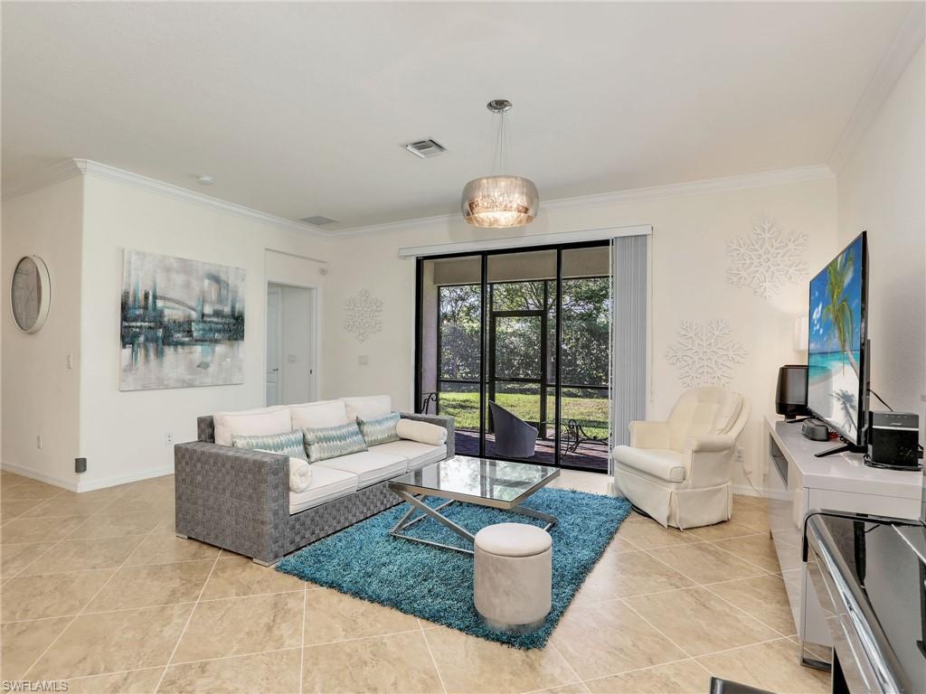 4212 Raffia Palm Circle Naples, FL 34119 - Photo 11 of 49 a living room with furniture and a flat screen tv
