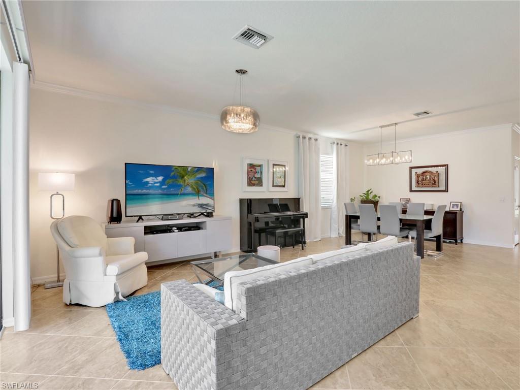 4212 Raffia Palm Circle Naples, FL 34119 - Photo 12 of 49 a living room with furniture and a flat screen tv