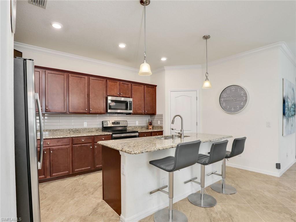 4212 Raffia Palm Circle Naples, FL 34119 - Photo 15 of 49 a kitchen with a sink cabinets and stainless steel appliances