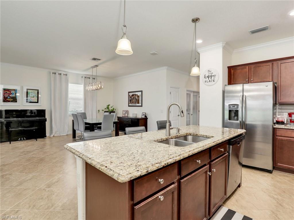 4212 Raffia Palm Circle Naples, FL 34119 - Photo 18 of 49 a kitchen with granite countertop a sink cabinets and refrigerator