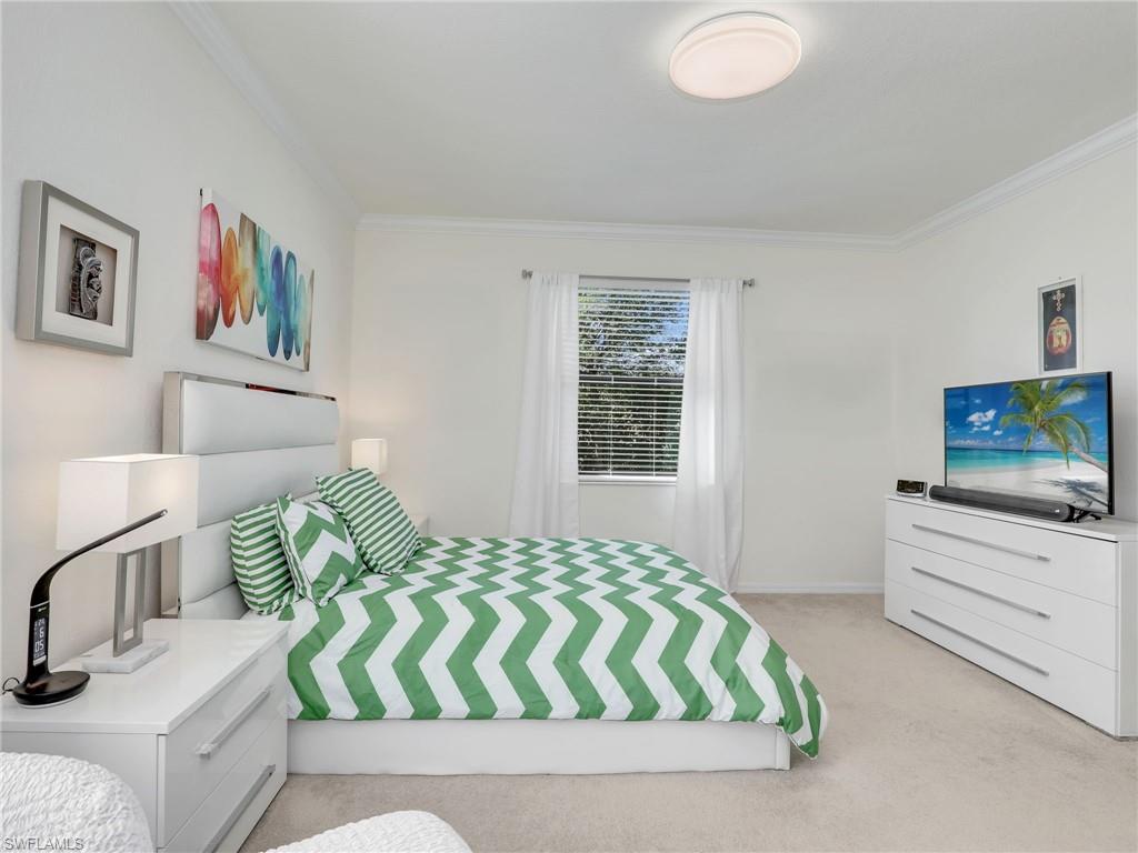 4212 Raffia Palm Circle Naples, FL 34119 - Photo 20 of 49 a bedroom with a bed and a flat screen tv