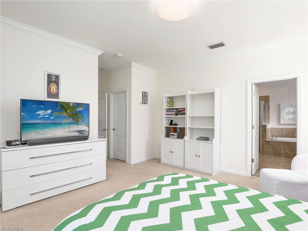 4212 Raffia Palm Circle Naples, FL 34119 - Photo 21 of 49 a living room with a bed and flat screen tv