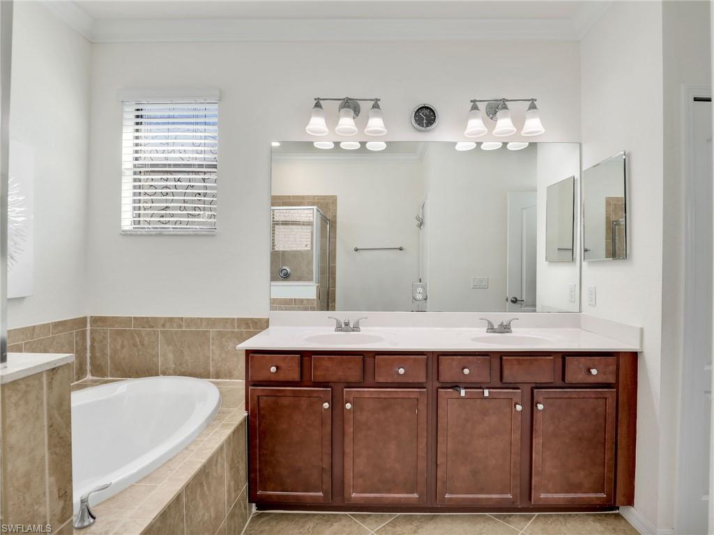 4212 Raffia Palm Circle Naples, FL 34119 - Photo 23 of 49 a bathroom with a tub sink and mirror