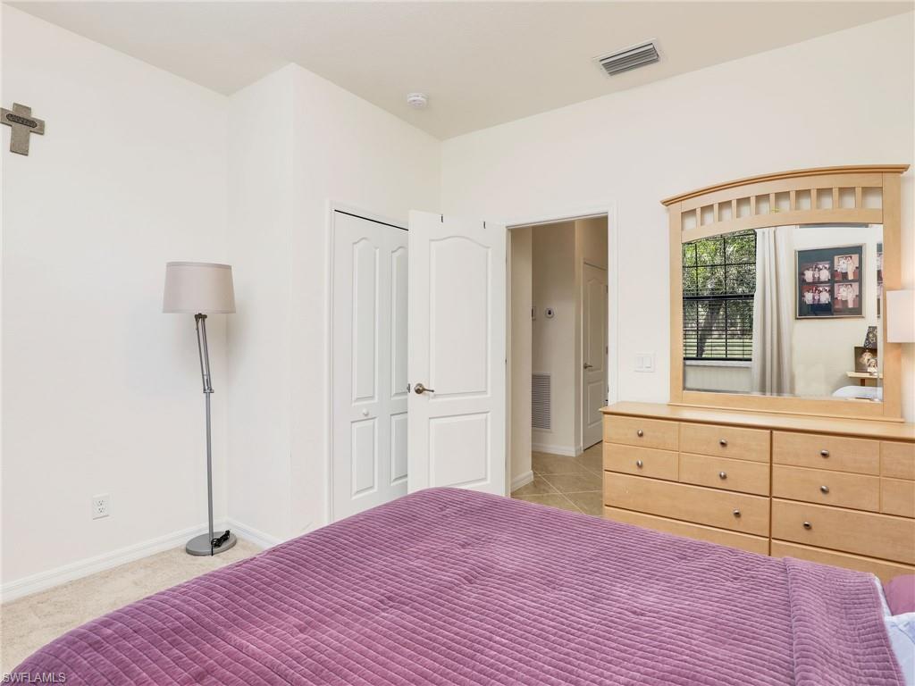 4212 Raffia Palm Circle Naples, FL 34119 - Photo 27 of 49 a bedroom with a bed and a dresser
