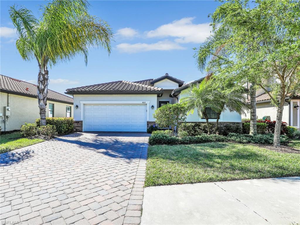 4212 Raffia Palm Circle Naples, FL 34119 - Photo 4 of 49 a front view of a house with garden