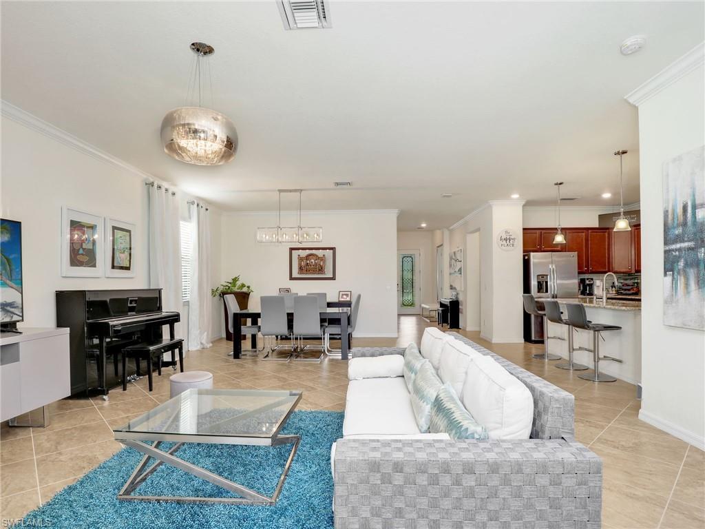 4212 Raffia Palm Circle Naples, FL 34119 - Photo 9 of 49 a living room with furniture a dining table and a piano