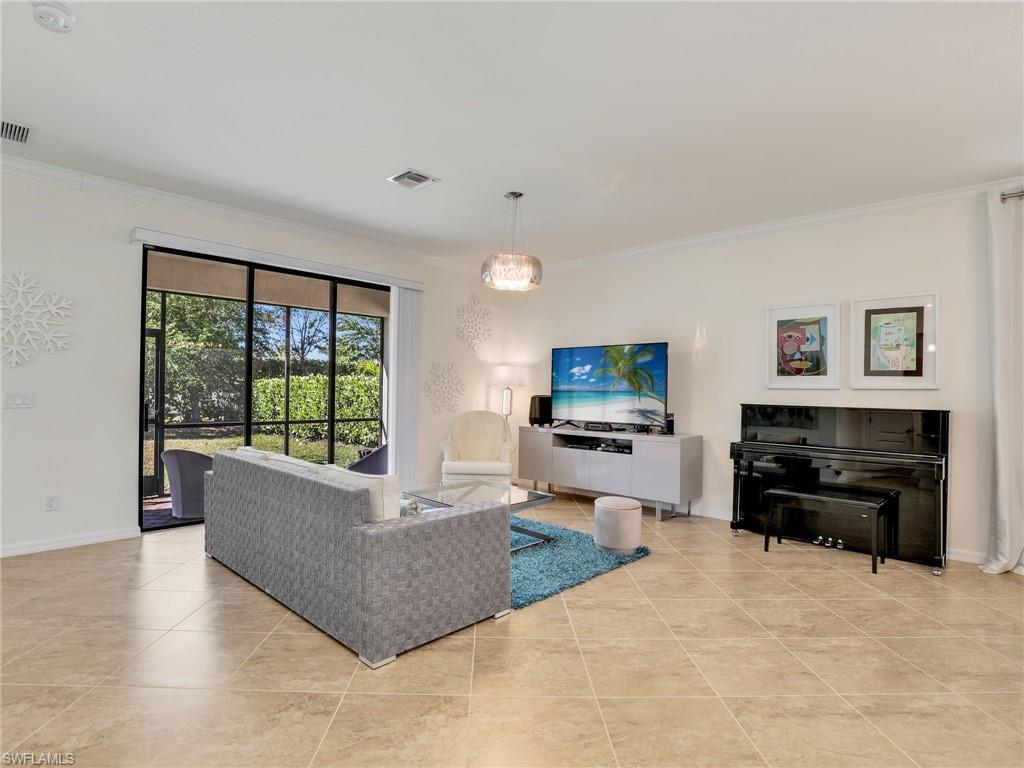 4212 Raffia Palm Circle Naples, FL 34119 - Photo 10 of 49 a living room with furniture and a flat screen tv