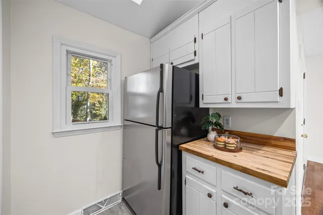 a kitchen with stainless steel appliances white cabinets and a refrigerator