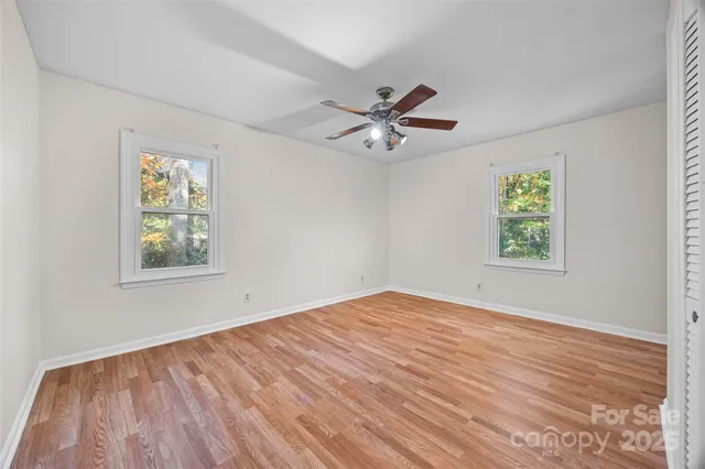 a view of empty room with window and ceiling fan