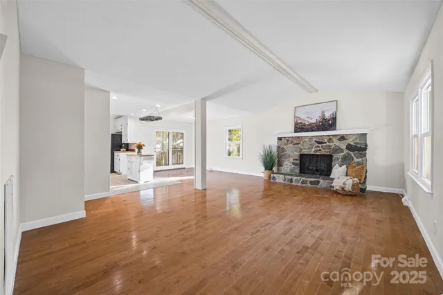 a view of a livingroom with a fireplace a chandelier and wooden floor