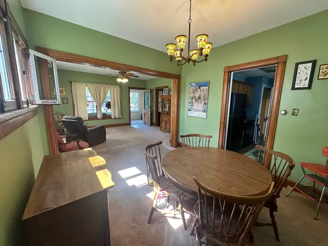 a view of a dining room with furniture a livingroom and chandelier