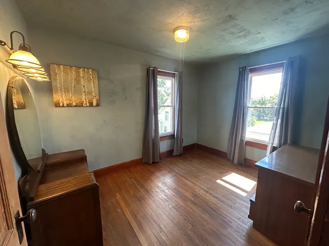 a view of a room with wooden floor and windows
