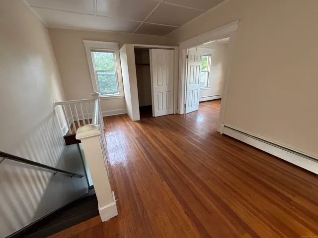 a view of hallway with wooden floor and window