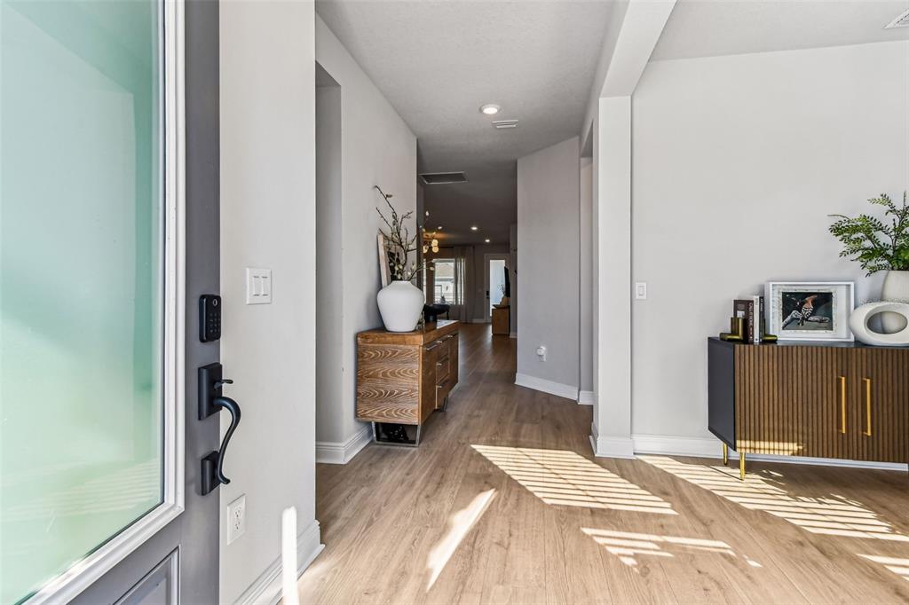 28748 Rambutan Drive Wesley Chapel, FL 33543 - Photo 11 of 37 a view of a hallway with wooden floor and furniture