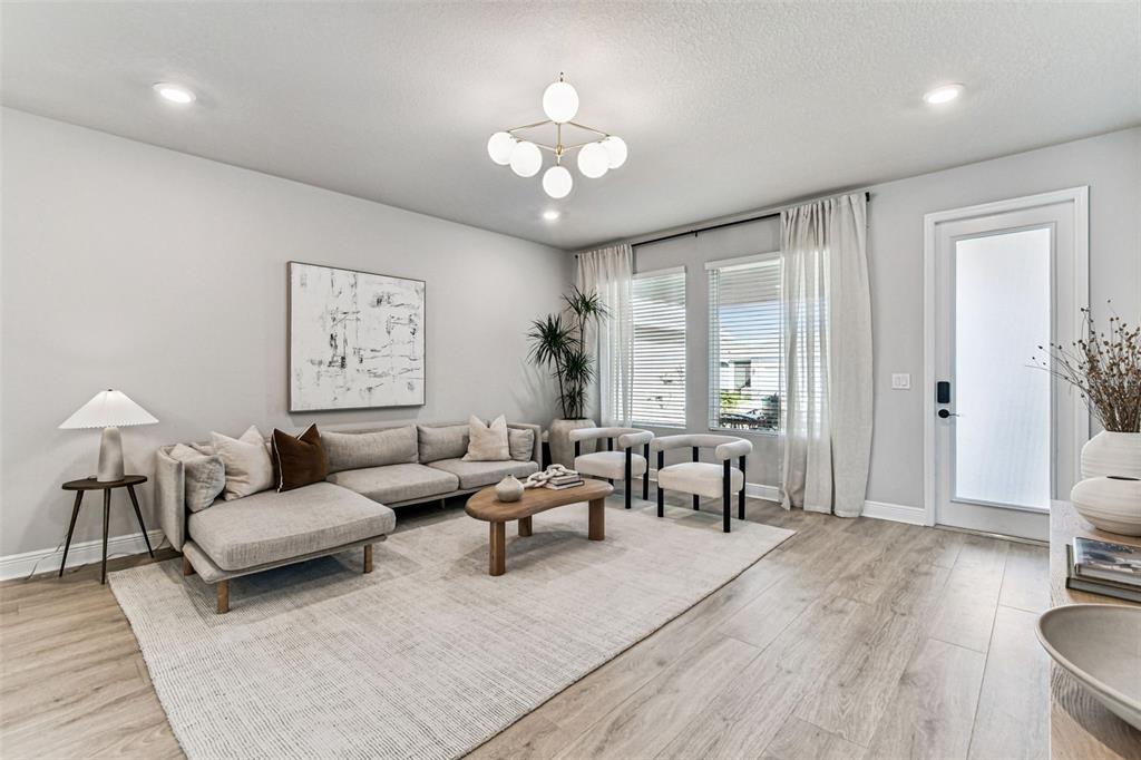 28748 Rambutan Drive Wesley Chapel, FL 33543 - Photo 18 of 37 a living room with furniture and a chandelier