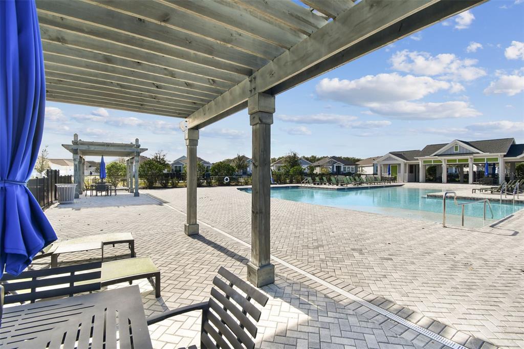 28748 Rambutan Drive Wesley Chapel, FL 33543 - Photo 32 of 37 a swimming pool with outdoor seating and a shower