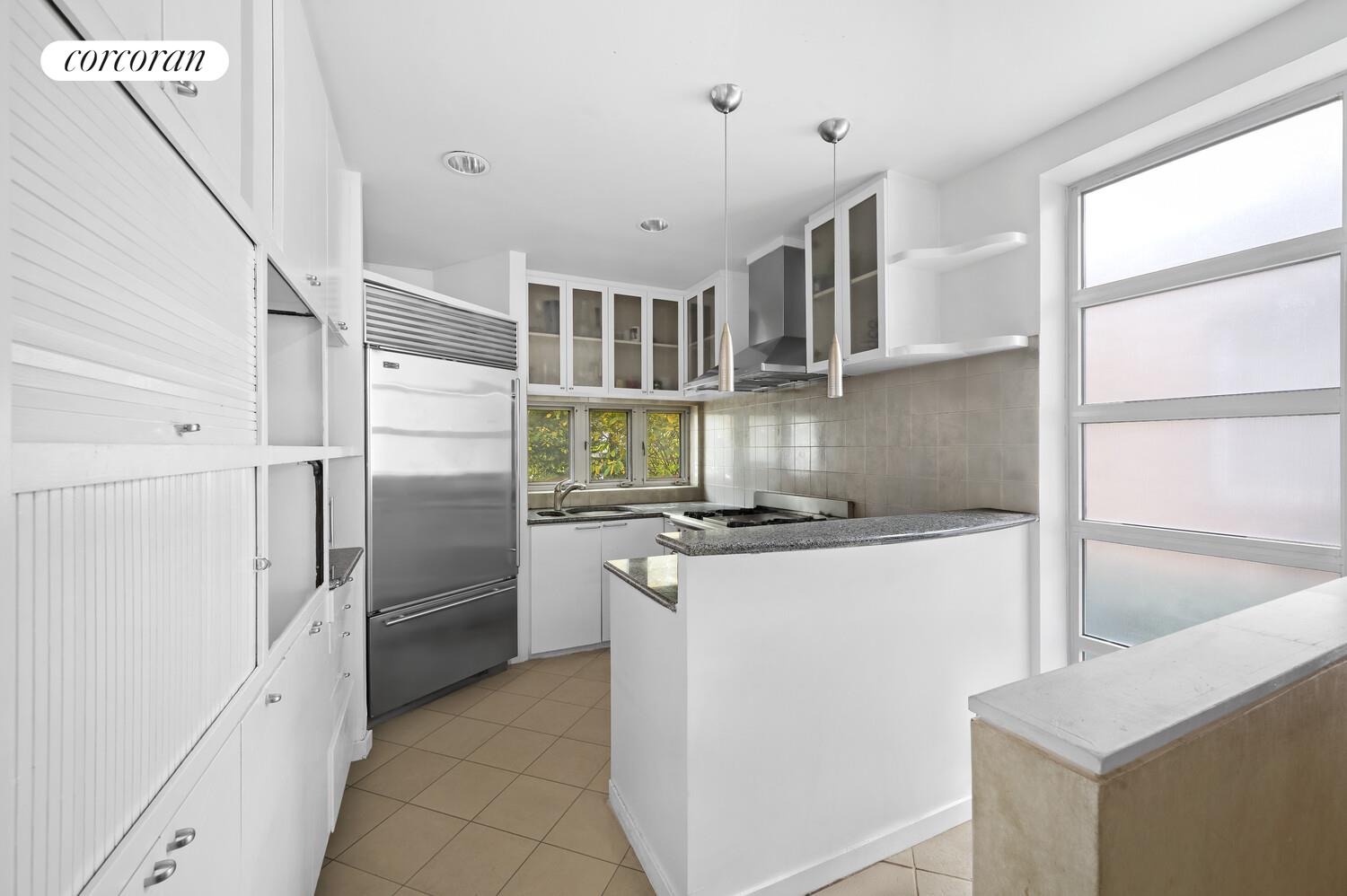 a kitchen with stainless steel appliances granite countertop a refrigerator a stove and a refrigerator with wooden floor