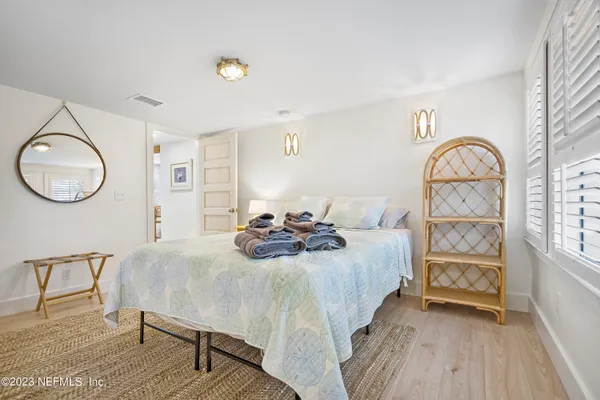 a bedroom with a bed a mirror and a window
