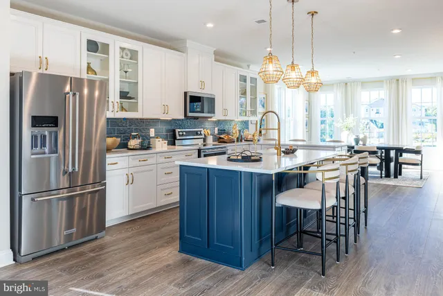 a kitchen with a refrigerator a stove a sink and dishwasher with wooden floor